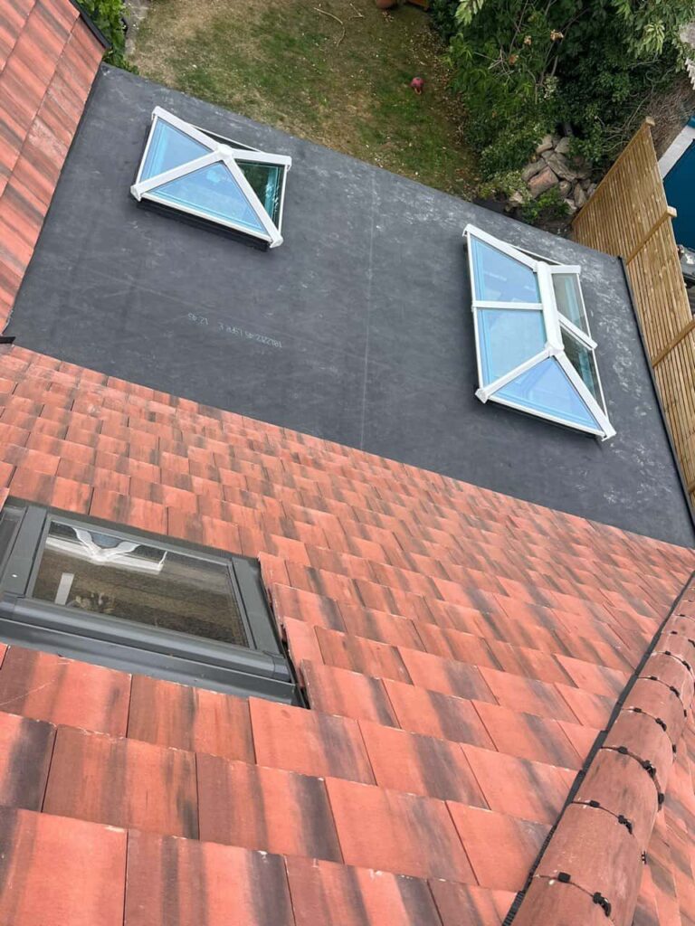 This is a photo taken from the roof ridge looking down a tiled pitched roof on to a flat roof. Works carried out by LJ Roofing Witney